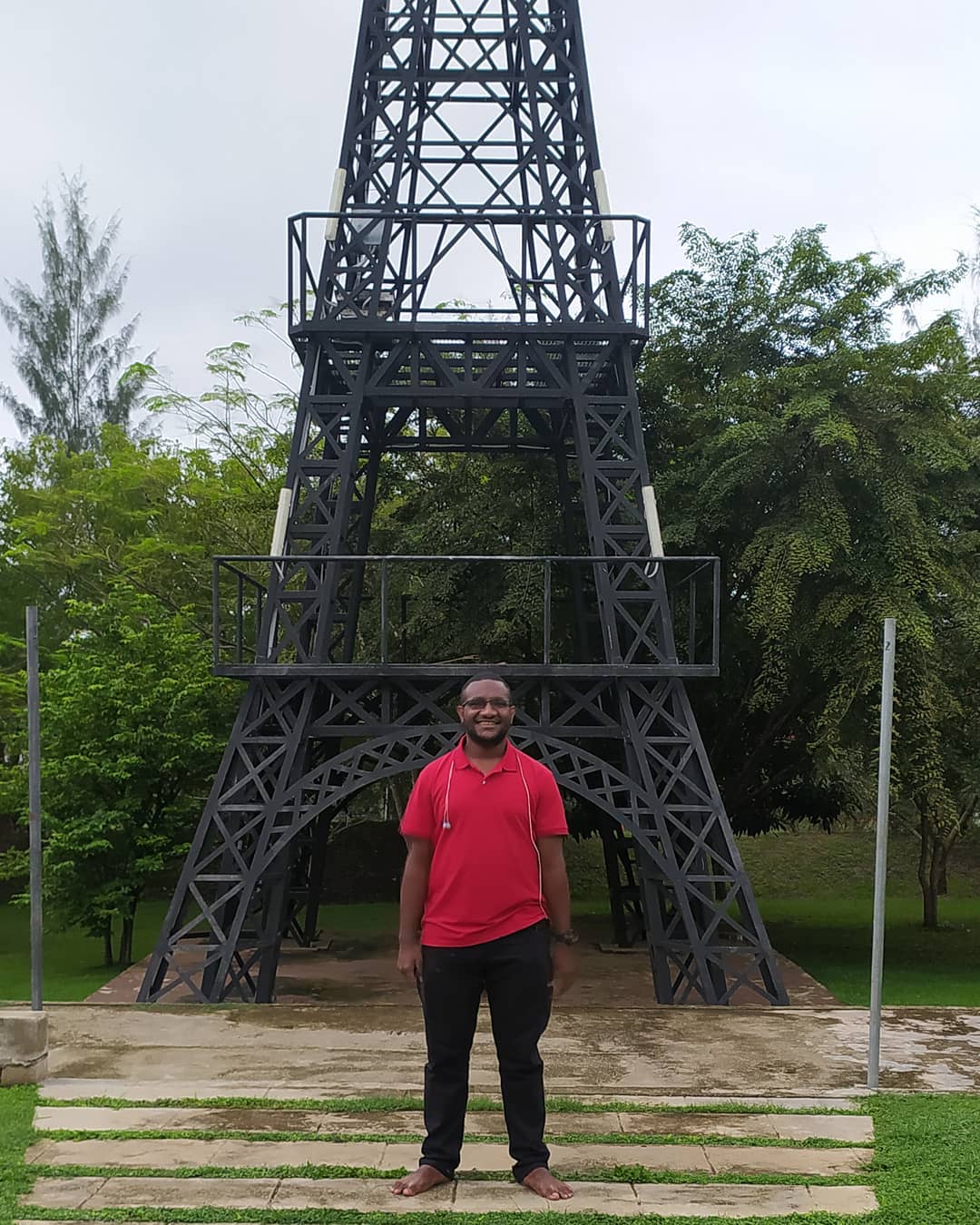 image of joshua junior kingal standing in front of the IBSUniversity Campus Eiffel Tower